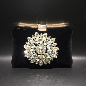 Macro detail of luxury black velvet evening bag with large crystal sunflower ornament