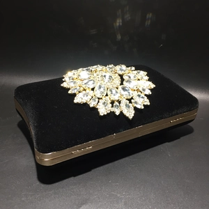 Detailed view of luxury black velvet evening clutch with sparkling sunflower crystal decor