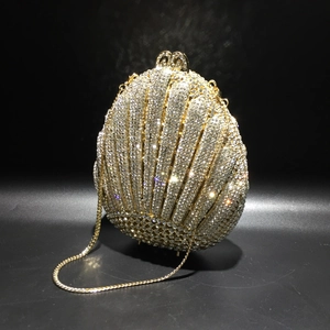 Macro shot of shell-shaped evening bag with silver crystals and gold metal chain