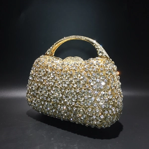 Nahaufnahme der goldenen Abendtasche mit aufwendigen Blumenmustern aus Strasssteinen