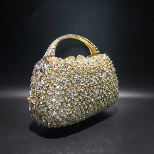 Detail der goldenen Abendtasche mit Kristallblumenmuster und funkelndem Strass-Griff