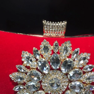 Macro detail of red velvet clutch with sparkling sunflower crystal rhinestones