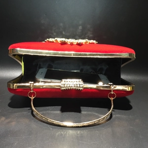 Detail view of the red velvet evening bag showing its capacity for a smartphone