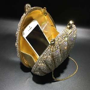 Detail view of gold shell evening bag with crystals showing interior capacity and chain