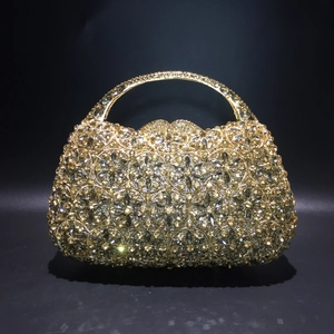 Detailsicht der luxuriösen goldenen Abendtasche mit Blumen-Kristallen und Metallgriff
