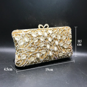 Detailed view of luxury evening clutch with crystal inlay and bow clasp showing 19cm size