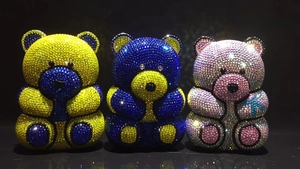 Detailed view of handmade bear evening clutch bags with sparkling colorful rhinestones