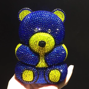 Close-up of bear-shaped evening bag with blue and yellow sparkling rhinestones