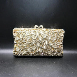 Detail of gold evening clutch with white cat eye stones and crystal rhinestones