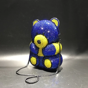 Detailed close-up of a teddy bear evening bag with blue and yellow rhinestones