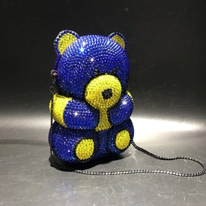 Detail of bear shaped evening clutch featuring blue and yellow crystals with metal chain