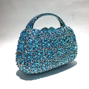 Nahaufnahme der himmelblauen Strasssteine in Blütenform auf einer Abendtasche