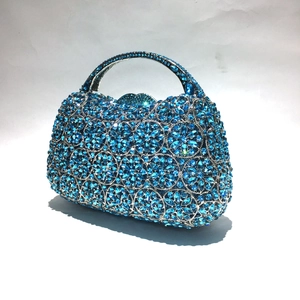Detail der luxuriösen blauen Abendtasche mit floralem Strassmuster und Metallgriff