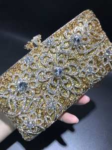 Macro detail of luxurious rhinestone hollow metal clutch with intricate floral crystal patterns