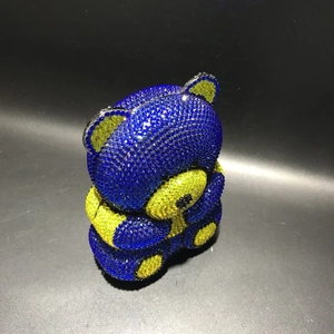 Close-up of bear-shaped evening bag with hand-set blue and yellow rhinestones