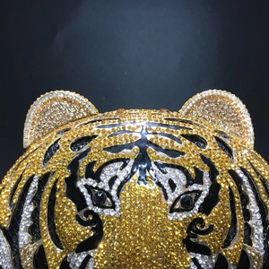 Macro detail of luxury tiger head evening bag featuring gold and black crystal rhinestones