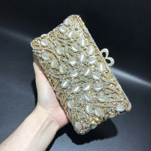 Detail of luxury gold evening clutch with cat eye stones and crystal bow clasp