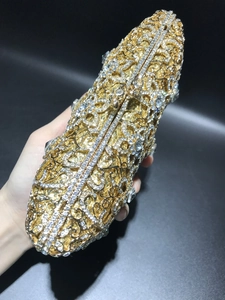 Close-up of gold hollow out crystal evening clutch bag with sparkling white rhinestones