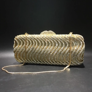 Macro detail of the elegant S-wave pattern with hand-set golden rhinestones on evening bag