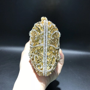 Close-up of luxury hollow metal evening clutch bag with gold finish and rhinestones