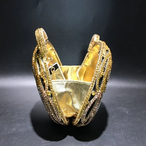 Macro view of heart-shaped evening bag with gold rhinestones and metallic chain