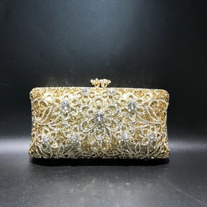 Macro shot of gold hollow metal evening bag with intricate rhinestone floral details