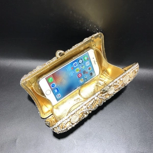 Detailed interior of a gold evening clutch showing rhinestone accents and chain strap