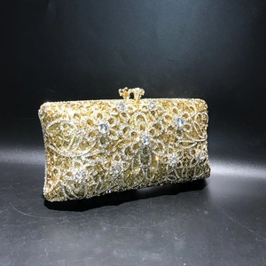 Detail of golden evening clutch with intricate hollow metalwork and sparkling rhinestones