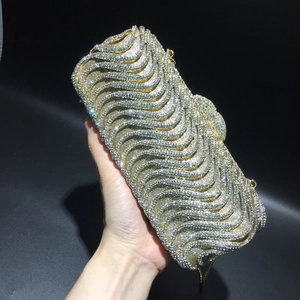 Detailed close-up of luxury S-shaped wavy rhinestone patterns on formal evening clutch