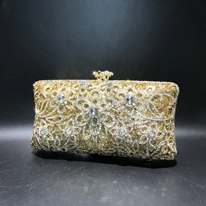 Close-up of golden hollow metal dinner bag with intricate crystal rhinestones detail