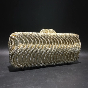 Detailed view of the sparkling golden rhinestone wave pattern on the evening clutch bag