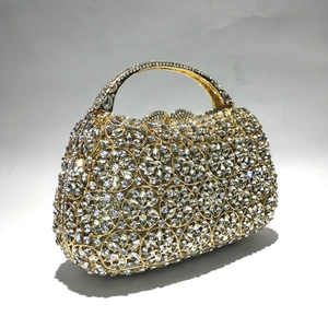 Makroansicht der goldenen Abendtasche mit Blumenkristallmustern und hartem Griff