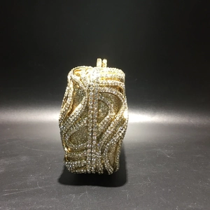 Close-up of gold evening clutch featuring rhinestone S-pattern texture and luxury finish