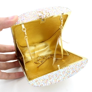 Detail view of colorful crystal evening clutch with gold leather interior and metal chain