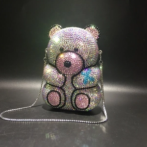 Detail of a bear-shaped evening clutch with gradient rhinestones and silver chain strap