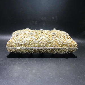 Detailed close-up of luxurious gold hollow floral evening bag with sparkling crystals