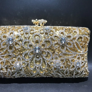 Close-up of luxury gold hollow metal clutch with sparkling crystal floral rhinestones