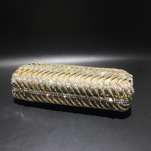 Macro shot of wavy S-pattern golden rhinestones on a luxury metal evening clutch bag