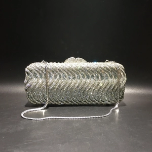 Detailed view of silver rhinestone evening clutch bag with sparkling wave pattern