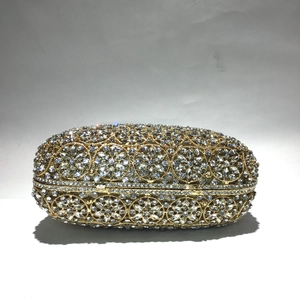 Detail einer goldenen Abendtasche aus Metall mit handgefertigtem floralem Strassmuster