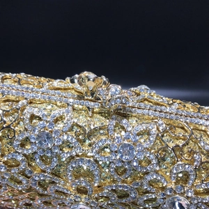 Detailed macro view of golden hollow-out floral patterns with sparkling white rhinestones