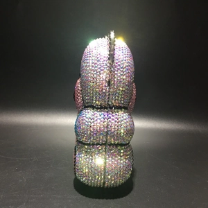 Detail view of colorful rhinestones on a bear-shaped evening clutch bag with lens flare