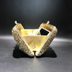 Detailed top view of gold hollow-out metal clutch bag showing internal phone storage capacity