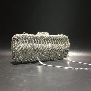 Detail of silver S-wave pattern evening clutch with rhinestones and heart clasp