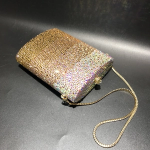 Macro detail of luxury evening clutch with champagne crystals and gold snake chain