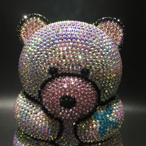 Detailed macro view of an bear-shaped evening bag with iridescent crystals and blue heart
