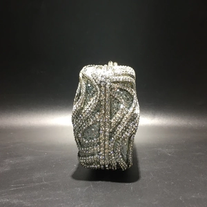 Detail of silver S-shaped wave pattern with sparkling rhinestones on an evening clutch bag