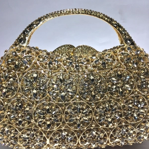 Detail einer goldenen Abendtasche mit Blumenmuster und funkelnden Strasssteinen