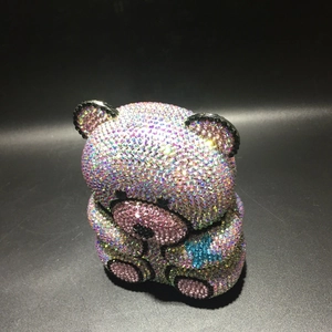 Macro view of crystal bear evening clutch with multicolored AB rhinestones on black background