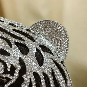 Macro detail of luxury tiger head evening bag with sparkling hand-set rhinestones